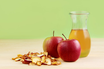 Apple juice. Fresh apple cider, red apples and dried apples on wooden background.