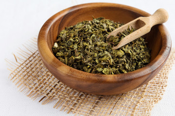Tea dry leaves in a wooden plate rustic
