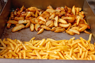 Steel container with roasted potato wedges, french fries