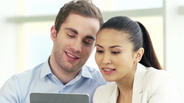 Two colleagues making fun of grimaces in office