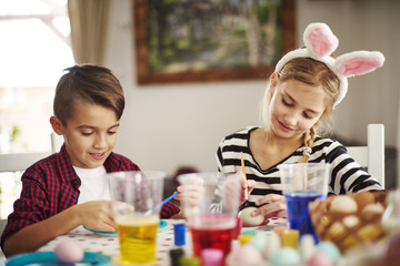 Fototapeta premium Elementary age kids painting eggs.