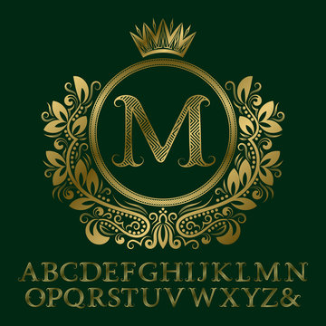 Zigzag striped gold letters and initial monogram in coat of arms form with crown. Elegant font and elements kit for logo design.
