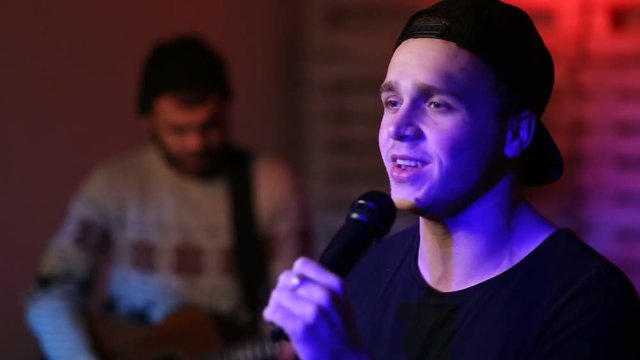 Young passionate male singer performing on stage