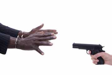 mani di uomo in manette e mani di donna con pistola