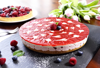 Delicious strawberry cake and fruit tart with decorative tulip bouquet. Summer cake arrangement.