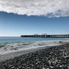 лазурное море с волнами у пирса