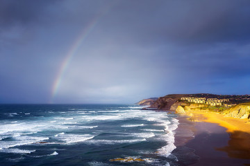 Fototapeta premium Sopelana beach with stormy clouds and a rainbow