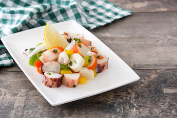 Traditional seafood ceviche from Peru on wooden background
