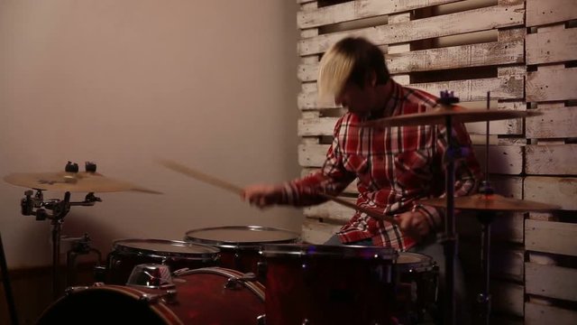 Expressive drummer playing on drums in club