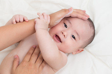 Mother applying baby powder for son