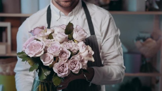 Close up view of florist preparing flower composition at workplace,bouquet of roses peone and lilac for valentine's day and women's day