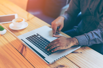 Hand of businessman using  laptop in coffee cafe