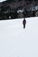 Fototapeta na wymiar Fille qui marche de dos sur la neige