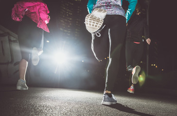 Three women running in the night in the city center