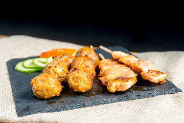 tasty grilled meat and vegetables skewers on a slate plate