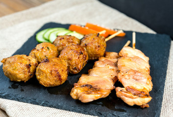 tasty grilled meat and vegetables skewers on a slate plate