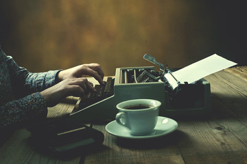 Woman is writing on old typewriter.