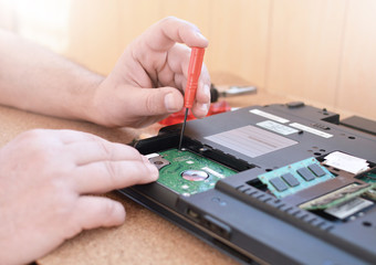 Engineer restores the laptop PC. Installing the hard drive hardware, RAM. Electronic repair shop, technology renovation, business, concept repairs.