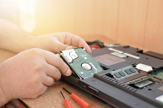 Engineer restores the laptop PC. Installing the hard drive hardware, RAM. Electronic repair shop, technology renovation, business, concept repairs.