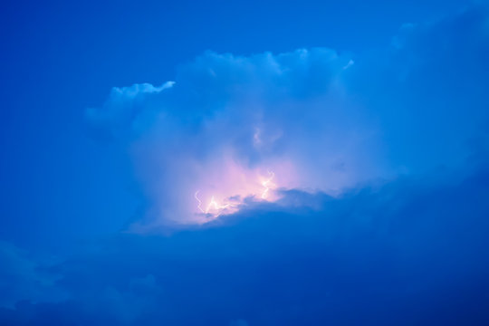 Lightnings in storm clouds. Peals of a thunder and the sparkling lightnings in clouds