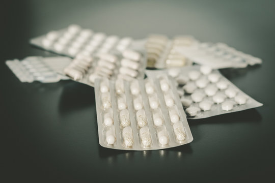 Tabletten auf Tisch, Metapher für Drogensucht oder Vitaminpräparate