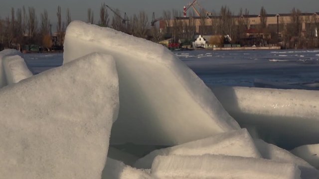 Winter in the industrial area of the port city. Ice conditions in the waters of the Dnepr River. Panoramma, horizontal wiring.