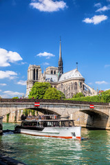 Naklejka premium Paris, Notre Dame cathedral with boat on Seine, France