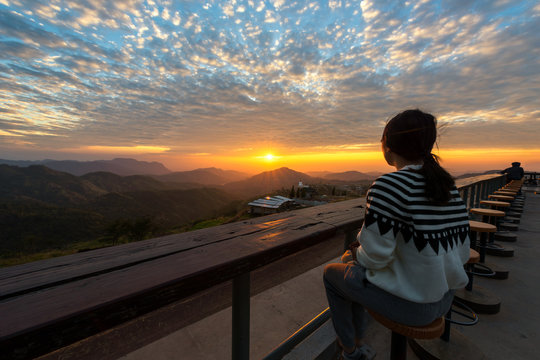 People sit on the wooden table and see Sunrise in the morning.