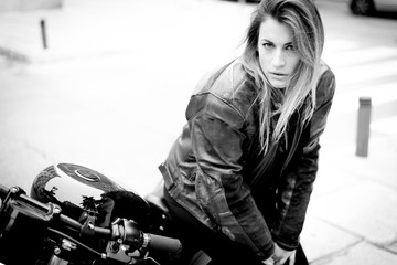 Fototapeta na wymiar biker girl in a leather jacket on a motorcycle