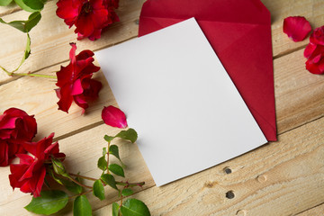 Love letter and valentine red roses on wooden background.  Valen