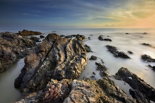 beautiful nature of unique rocks formation at Pandak Beach located in Terengganu,Malaysia over stunning sunrise background.soft focus image due to long exposure