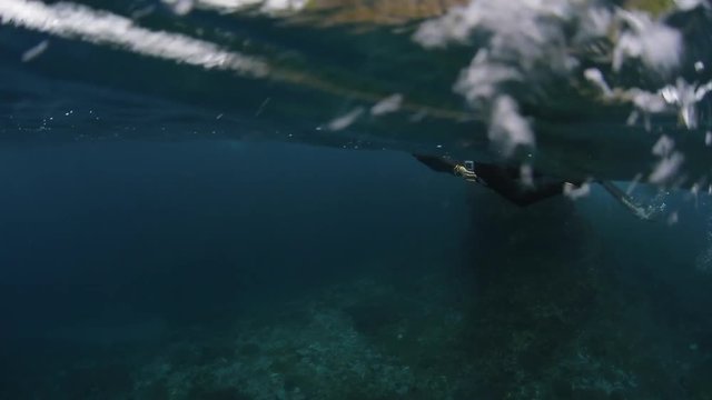 Split underwater shoot of swimmer on the sea surface