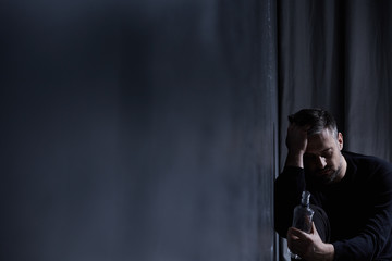 Man staring at alcohol bottle