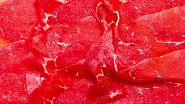Bresaola slices red meat background texture still image zoom in
