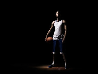 basketball player standing in durkness on parquet with ball