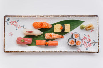 Sushi Set Include Maguro, Hamachi, Salmon, Kani, Shrimp, Tamagoyaki and Salmon Maki Roll Served with Wasabi and Prickled Ginger on Japanese Painted Stone Plate.