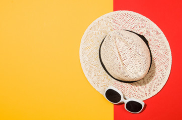 Woman's accessories flat lay on colorful background. Top view. Red and yellow pastel colors with copy space around products. Horizontal image or photograph.