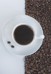coffee concept/white cup of coffee on coffee beans background top view