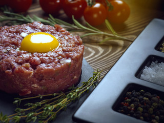 Beef tartar with an egg on a stone plate.