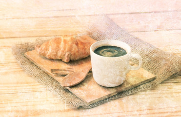 Double exposure of Coffee cup and croissant with old grunge ceme