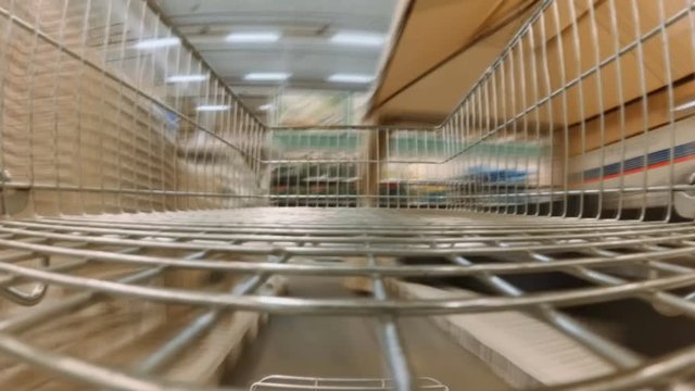 Time lapse video from inside the shopping cart of going between shelves at big supermarket