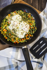scrambled eggs with vegetables in a pan. hearty and healthy lunch