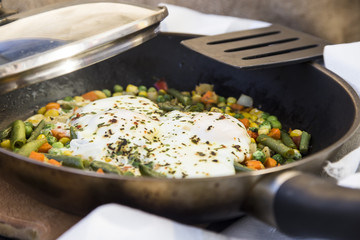 scrambled eggs with vegetables in a pan. hearty and healthy lunch