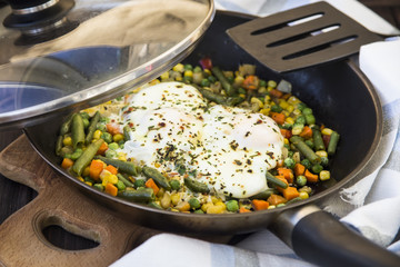 scrambled eggs with vegetables in a pan. hearty and healthy lunch