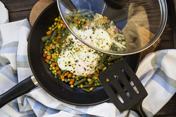 scrambled eggs with vegetables in a pan. hearty and healthy lunch