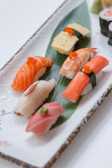 Sushi Set Include Maguro, Hamachi, Salmon, Kani, Shrimp, Tamagoyaki and Salmon Maki Roll Served with Wasabi and Prickled Ginger on Japanese Painted Stone Plate.