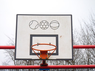 A basketball hoop on a public sports facility in a park