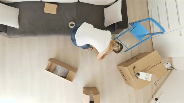 View from the ceiling on young family moving to a new house and carrying boxes