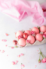 Fototapeta na wymiar Pink Easter eggs on light background. Copyspace. Still life photo of lots of pink easter eggs.Background with easter eggs. Pink eggs and roses. Easter photo concept