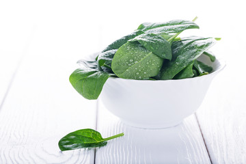 Fresh raw spinach in white bowl